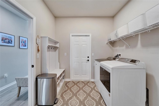 laundry area featuring baseboards, separate washer and dryer, and laundry area