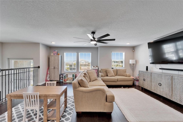 living area featuring a textured ceiling, a ceiling fan, and dark wood-style flooring