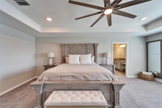 bedroom with visible vents, a tray ceiling, a textured ceiling, baseboards, and light colored carpet