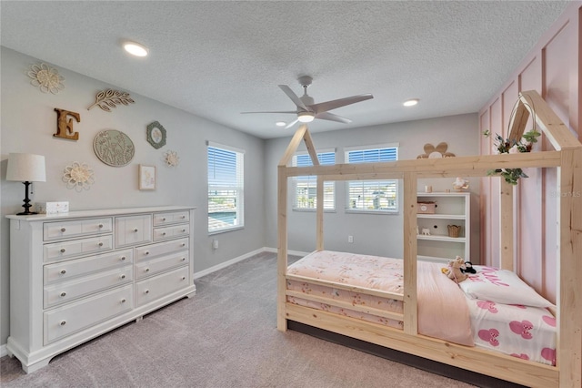 bedroom featuring light colored carpet, a textured ceiling, and baseboards