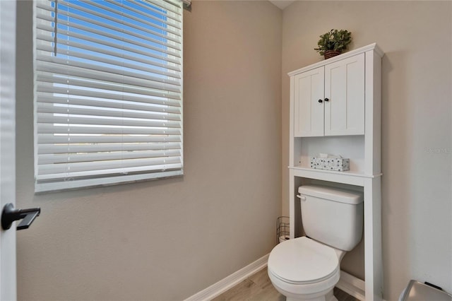 bathroom featuring toilet, wood finished floors, and baseboards