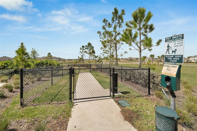 view of gate featuring a lawn and fence