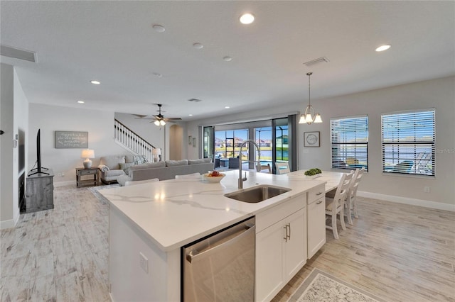 kitchen with recessed lighting, a sink, white cabinetry, stainless steel dishwasher, and an island with sink