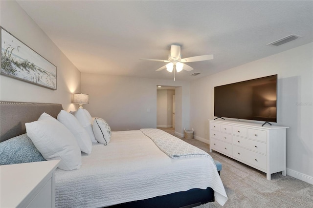 bedroom featuring baseboards, a ceiling fan, visible vents, and light colored carpet