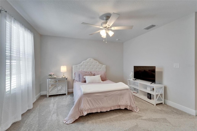 carpeted bedroom with a ceiling fan, visible vents, and baseboards