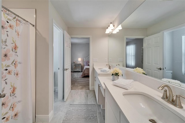 ensuite bathroom with double vanity, toilet, a sink, and ensuite bathroom