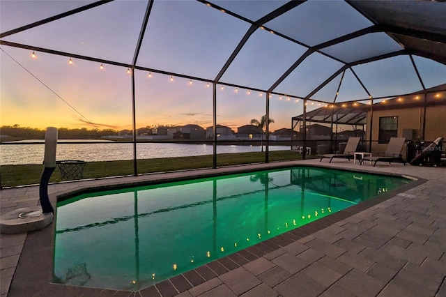 pool with a lanai, a water view, and a patio