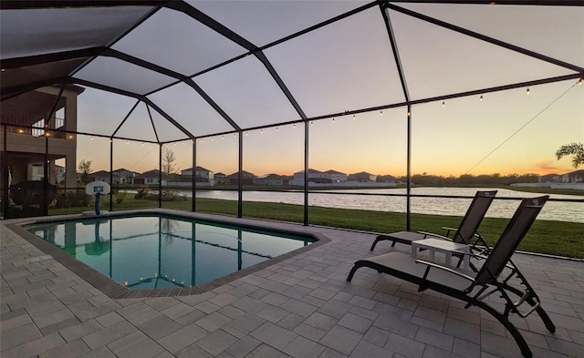 outdoor pool featuring a lanai, a lawn, and a patio