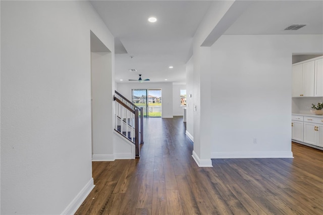 hallway with baseboards, stairs, visible vents, and dark wood-style flooring