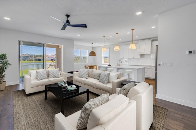 living room featuring recessed lighting, dark wood finished floors, baseboards, and ceiling fan