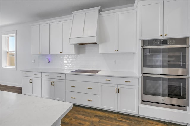 kitchen with dark wood-style floors, light countertops, stainless steel double oven, and black electric cooktop