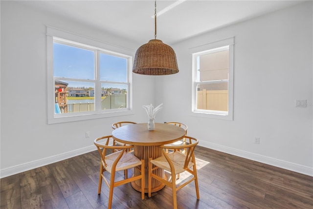 dining space featuring baseboards and dark wood finished floors