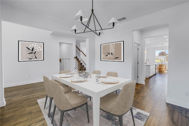 dining room with baseboards, visible vents, dark wood-style floors, stairway, and a chandelier