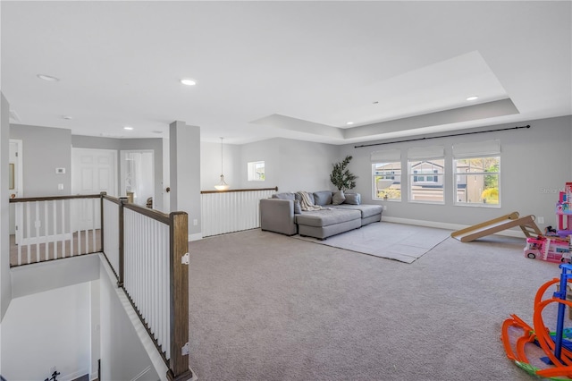 living area with baseboards, a tray ceiling, carpet, and recessed lighting