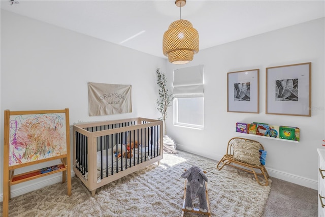 carpeted bedroom with a nursery area and baseboards