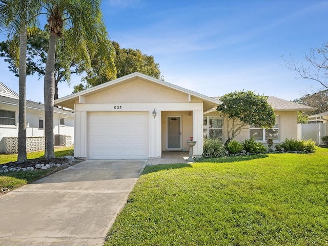 view of front of house with a front lawn, concrete driveway, fence, and stucco siding