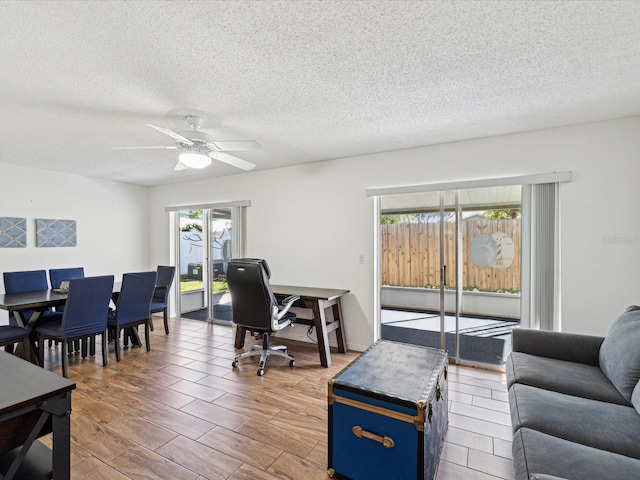 office space with a textured ceiling and ceiling fan