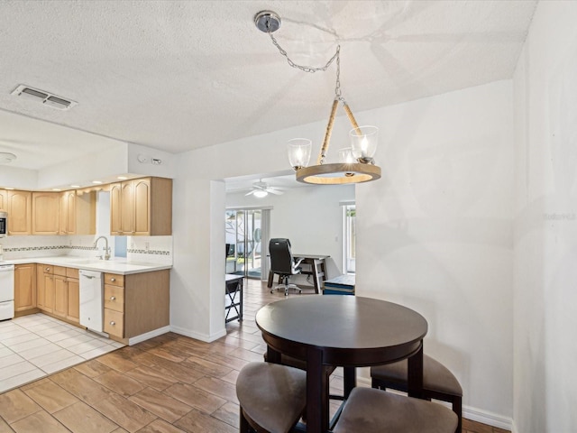 dining area featuring baseboards, visible vents, and a textured ceiling