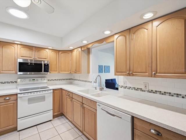 kitchen featuring white appliances, light tile patterned floors, a sink, light countertops, and tasteful backsplash