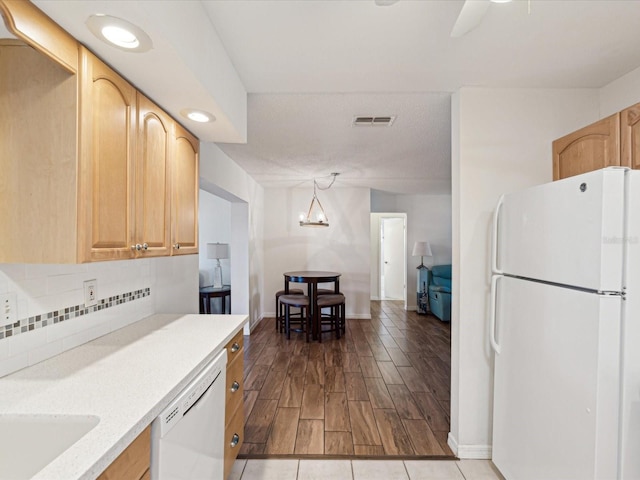 kitchen featuring white appliances, tasteful backsplash, light countertops, and visible vents