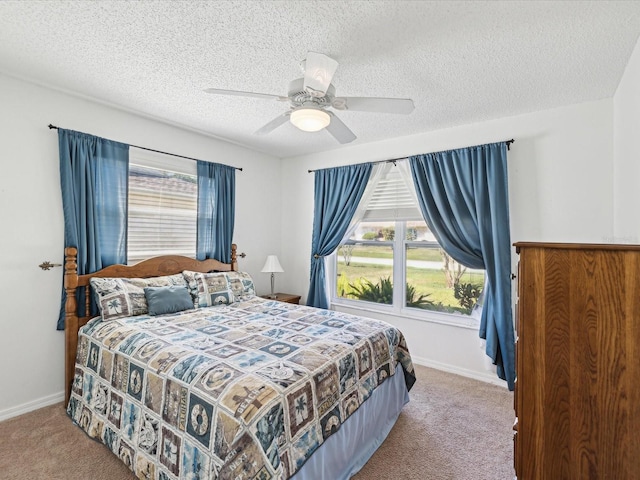 bedroom featuring baseboards, a ceiling fan, carpet flooring, and a textured ceiling