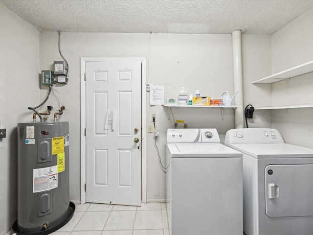 laundry room featuring light tile patterned floors, laundry area, water heater, a textured ceiling, and washer and clothes dryer