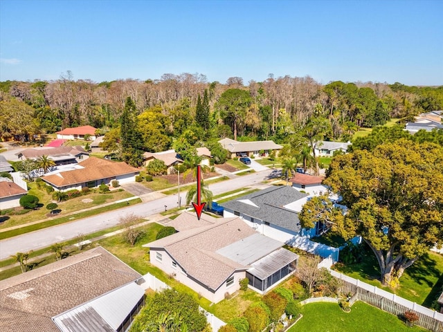 drone / aerial view featuring a residential view and a wooded view