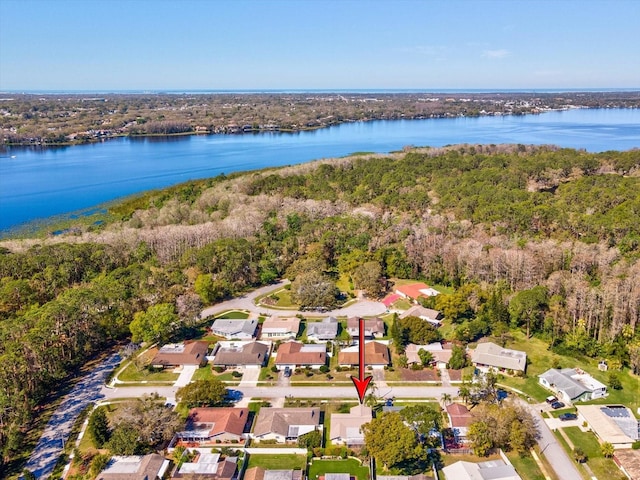 drone / aerial view with a view of trees, a water view, and a residential view