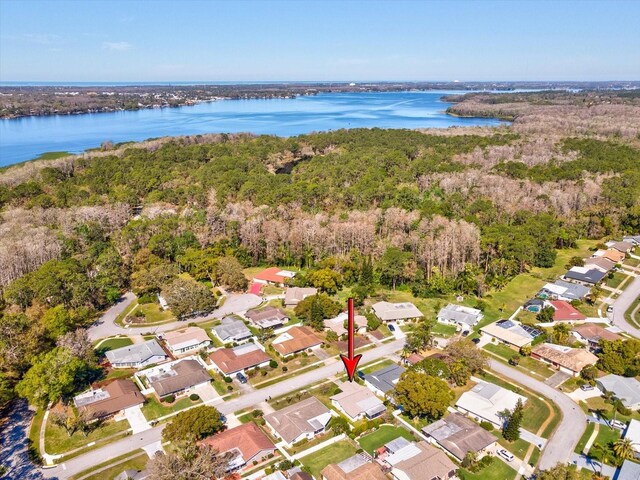 drone / aerial view with a forest view, a water view, and a residential view