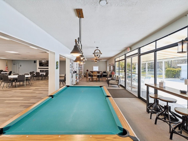 rec room with billiards, wood finished floors, and a textured ceiling