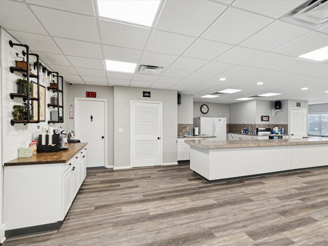 kitchen with visible vents, freestanding refrigerator, and wood finished floors