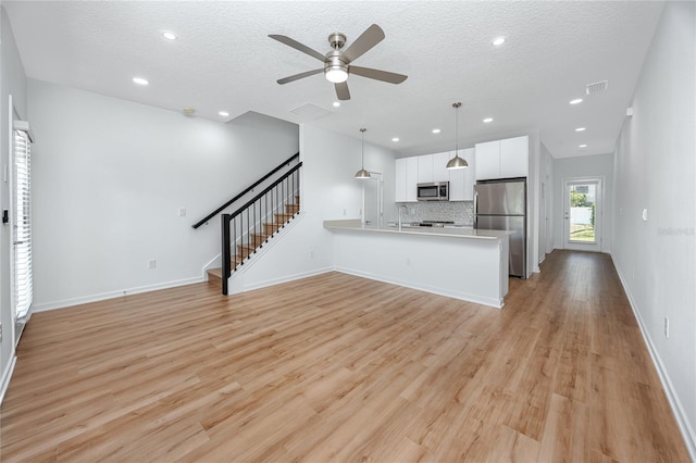 3402 E 28th Ave Unit 7, Tampa, FL 33605 - unfurnished living room featuring stairway, a ceiling fan, light wood finished floors, a textured ceiling, and baseboards