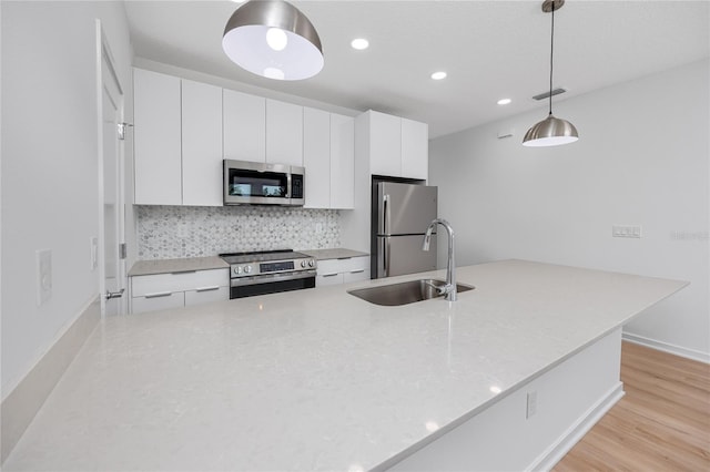 3402 E 28th Ave Unit 7, Tampa, FL 33605 - kitchen with stainless steel appliances, a sink, backsplash, recessed lighting, and white cabinetry