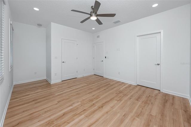 3402 E 28th Ave Unit 7, Tampa, FL 33605 - unfurnished bedroom with light wood-style floors, a textured ceiling, baseboards, recessed lighting, and multiple closets