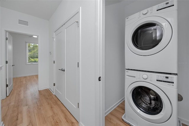 3402 E 28th Ave Unit 7, Tampa, FL 33605 - laundry room with stacked washing machine and dryer, light wood-style flooring, and baseboards