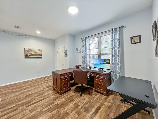 office area featuring baseboards, visible vents, and light wood finished floors