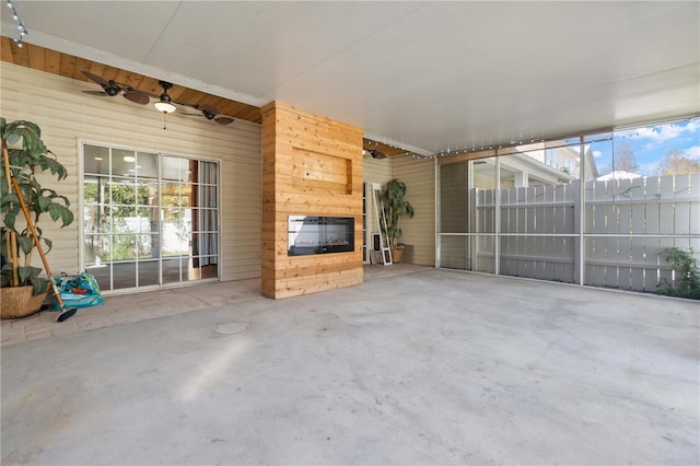 unfurnished sunroom featuring a glass covered fireplace