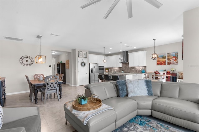 living area with a ceiling fan, baseboards, light tile patterned floors, and recessed lighting