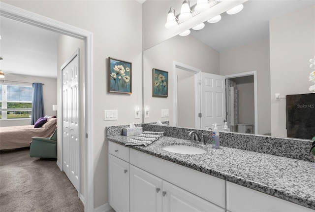 bathroom featuring vanity, ensuite bath, and baseboards
