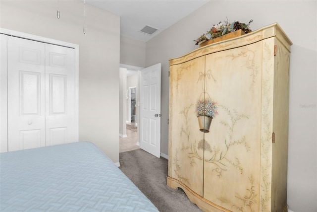 carpeted bedroom with a closet and baseboards