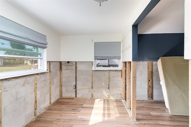 kitchen with concrete block wall and light wood-type flooring