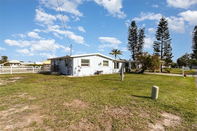 exterior space with fence and a lawn