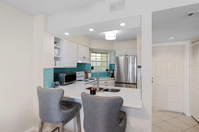 kitchen with open shelves, visible vents, decorative backsplash, appliances with stainless steel finishes, and a sink