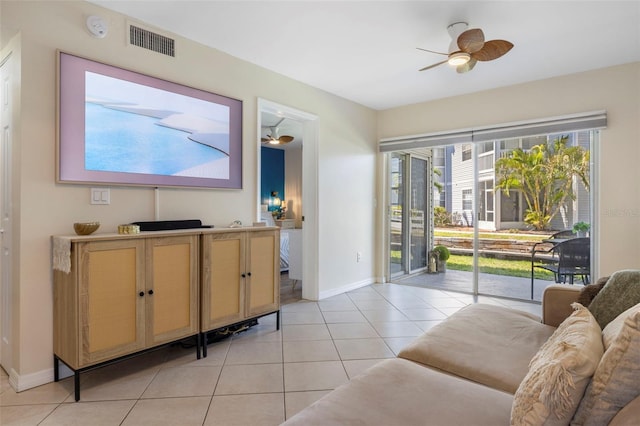 living area with visible vents, ceiling fan, baseboards, and light tile patterned floors