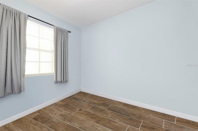 spare room with dark wood-style floors and baseboards