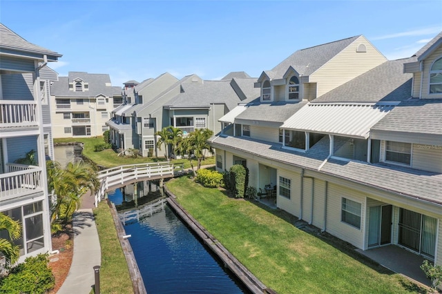 view of pool with a residential view, a water view, and a lawn