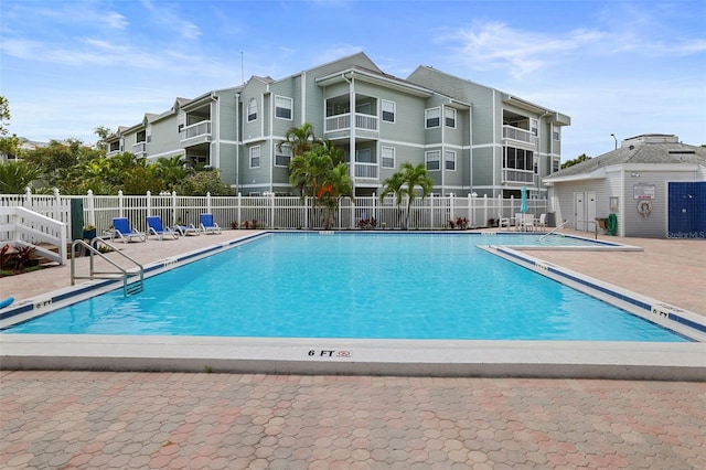 pool with a patio area and fence