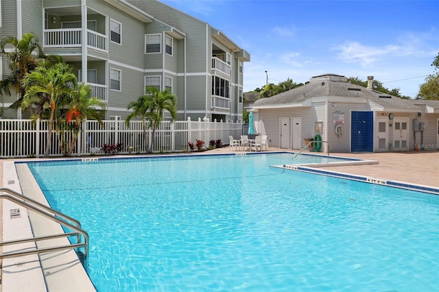 pool with a patio area and fence