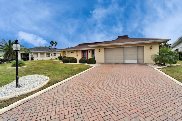 single story home featuring a garage, stucco siding, decorative driveway, and a front yard