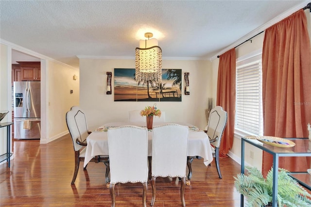 dining area with baseboards, dark wood-type flooring, crown molding, and a textured ceiling